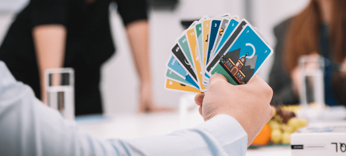 Planungspoker Karten im Vordergrund einer Konferenz